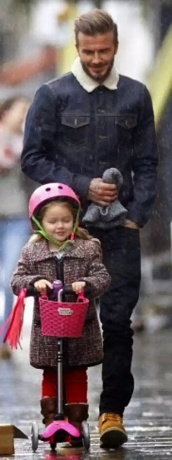 David Beckham looks on proudly as his daughter scoots through London