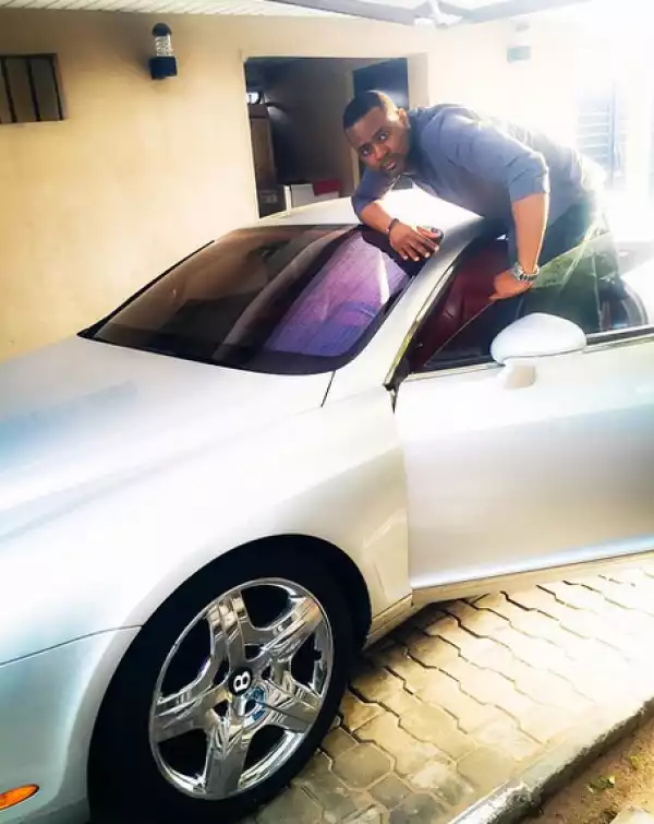 Handsome and rich DJ Xclusive poses with his Bentley...